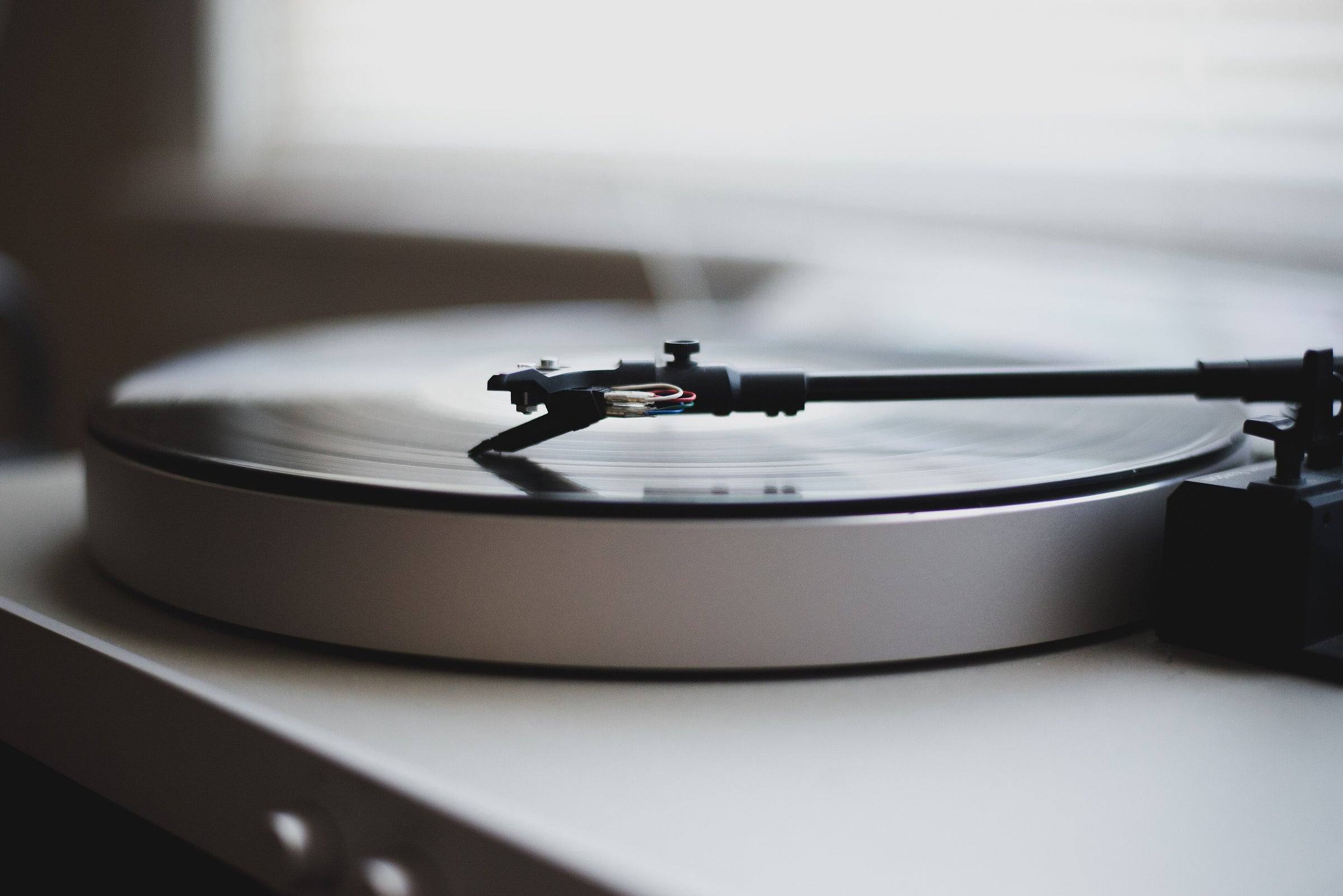 Un tocadiscos claro con un disco puesto, de cerca